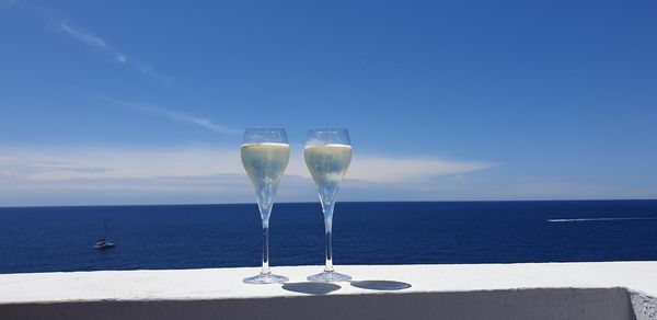 Wine glass against blue sea and sky