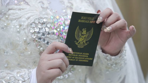 Midsection of bride holding book