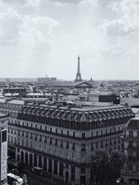 Buildings in city against cloudy sky