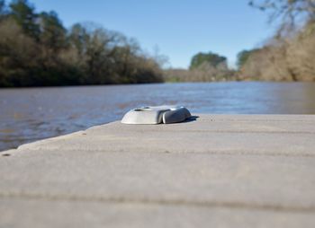 Close-up of retaining wall by lake against clear sky