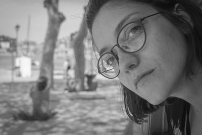 Close-up portrait of young woman wearing eyeglasses at beach