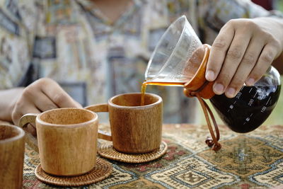 Midsection of man pouring tea