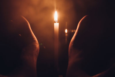 Close-up of lit candle in the dark