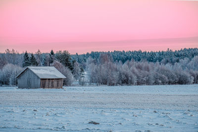 Scenic view of frozen field against sky during winter