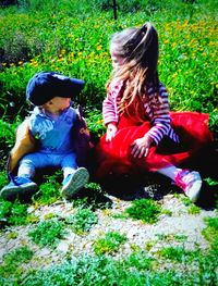 Rear view of girl sitting on grass