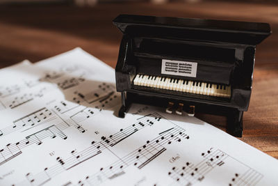 Close-up of piano with sheet music on floor