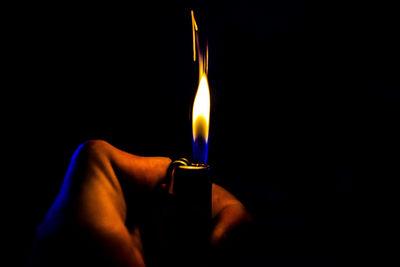 Close-up of lit candle in dark room