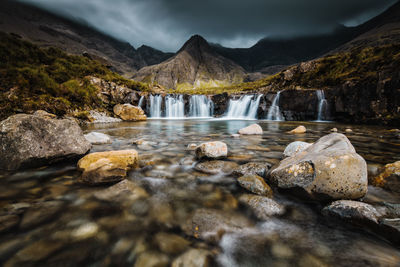 Scenic view of waterfall in mountains