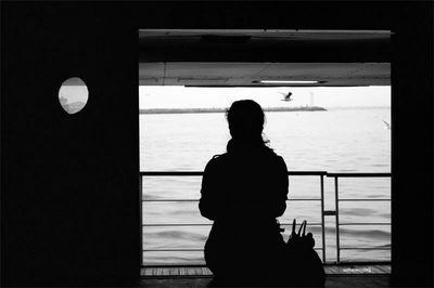 Rear view of woman standing in the dark