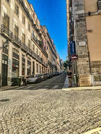 Surface level of street amidst buildings against sky