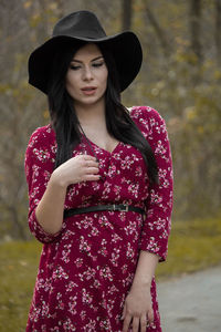 Beautiful young woman wearing hat standing outdoors