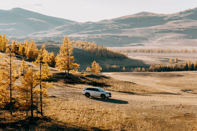 Car on road by mountains against sky