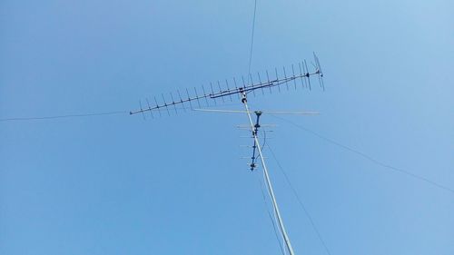 Low angle view of birds flying against clear blue sky