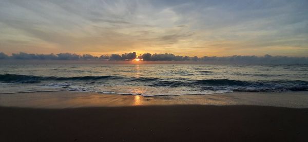 Scenic view of beach against sky during sunset