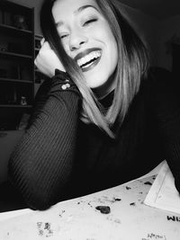 Portrait of a smiling young woman sitting at home