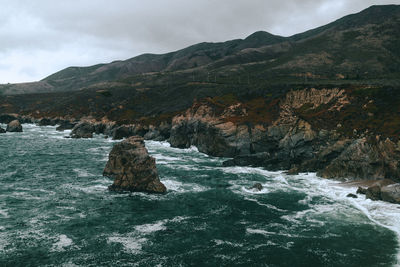 Rock formation in sea against sky