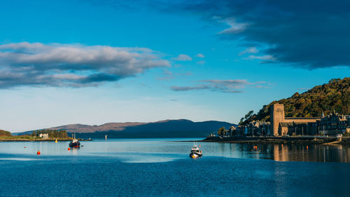 Boats in lake against blue sky