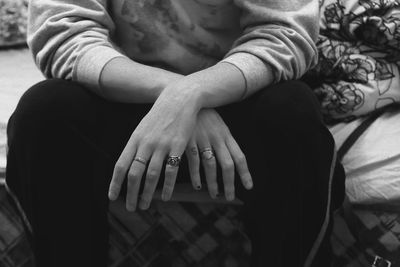 Midsection of young woman sitting on sofa at home