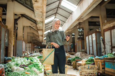 Portrait of young woman standing in market
