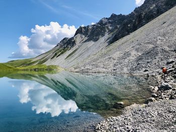 Scenic view of lake by mountains against sky