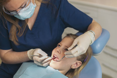 Dentist examining patient mouth in medical clinic