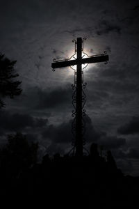 Low angle view of silhouette trees against cloudy sky