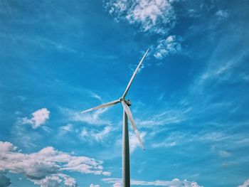 Low angle view of wind turbine against blue sky