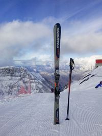 Ski lift by snowcapped mountain against sky