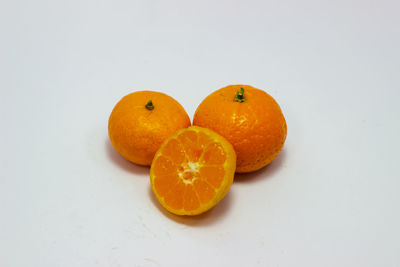 High angle view of orange fruit on white background