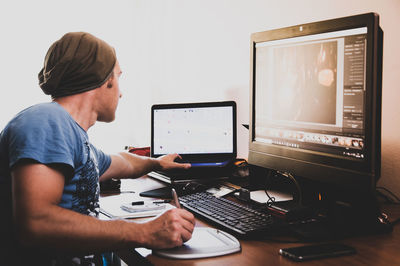 Businessman using computers at desk