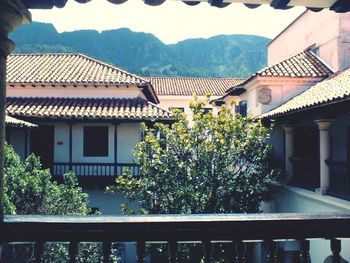 Houses by trees against sky