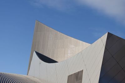 Low angle view of modern building against blue sky