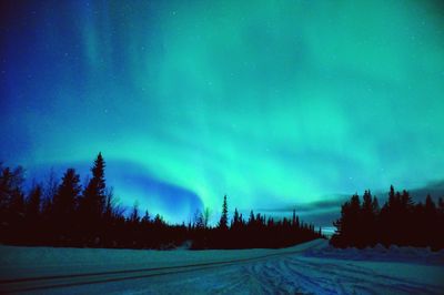 Scenic view of snow covered land against sky at night