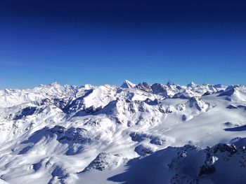 Scenic view of snowcapped mountains against clear blue sky