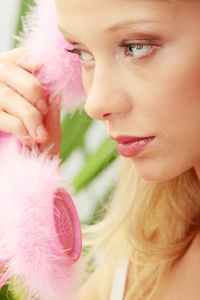 Close-up portrait of woman holding pink flower