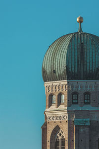 Low angle view of church tower in munich against clear blue sky