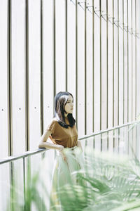 Thoughtful woman standing against wall