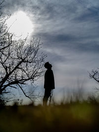 Silhouette man standing on field against sky