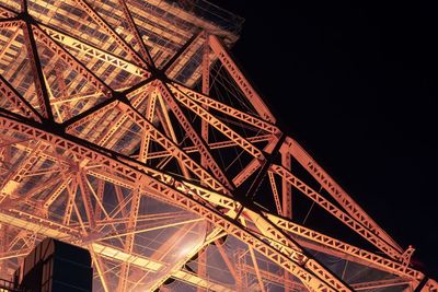 Low angle view of illuminated tower bridge at night