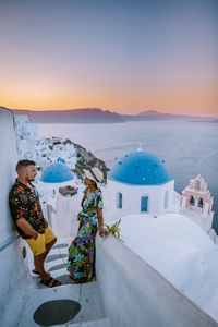 Man standing by sea against sky during sunset