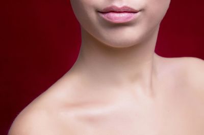 Midsection of young woman against red background