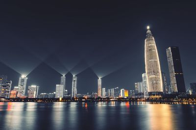 Illuminated buildings against sky at night