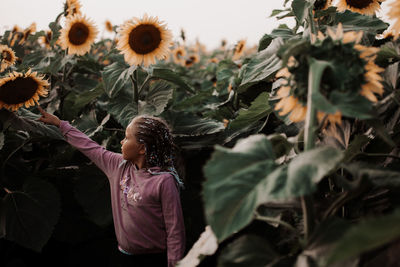 Rear view of women standing on sunflower