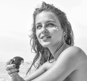 Portrait of smiling young woman against sky