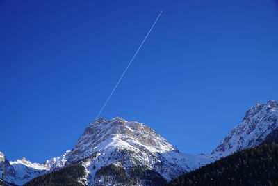 Low angle view of vapor trail against clear blue sky