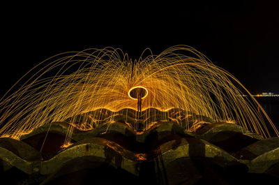 Illuminated ferris wheel against sky at night