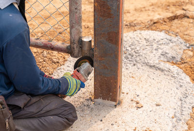 Woker use electric wheel grinding on hinge door in construction site.