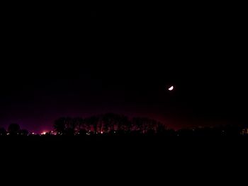 Silhouette landscape against sky at night