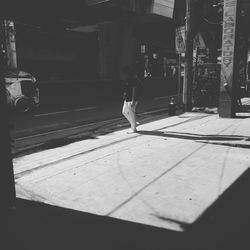 Rear view of woman walking on street in city