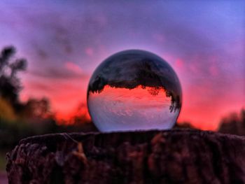 Close-up of crystal ball against sky during sunset